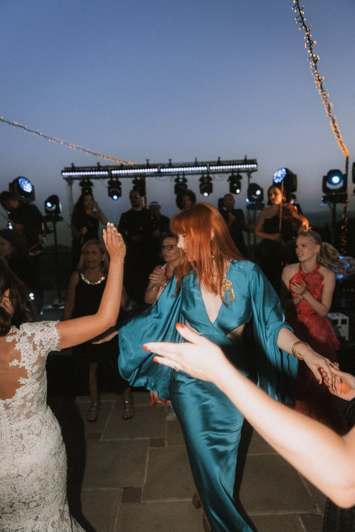 Lively wedding reception dance floor with guests in formal attire.