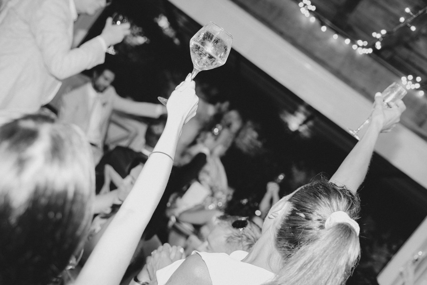 Monochrome wedding party images capturing joyful moments on the dance floor at a reception.