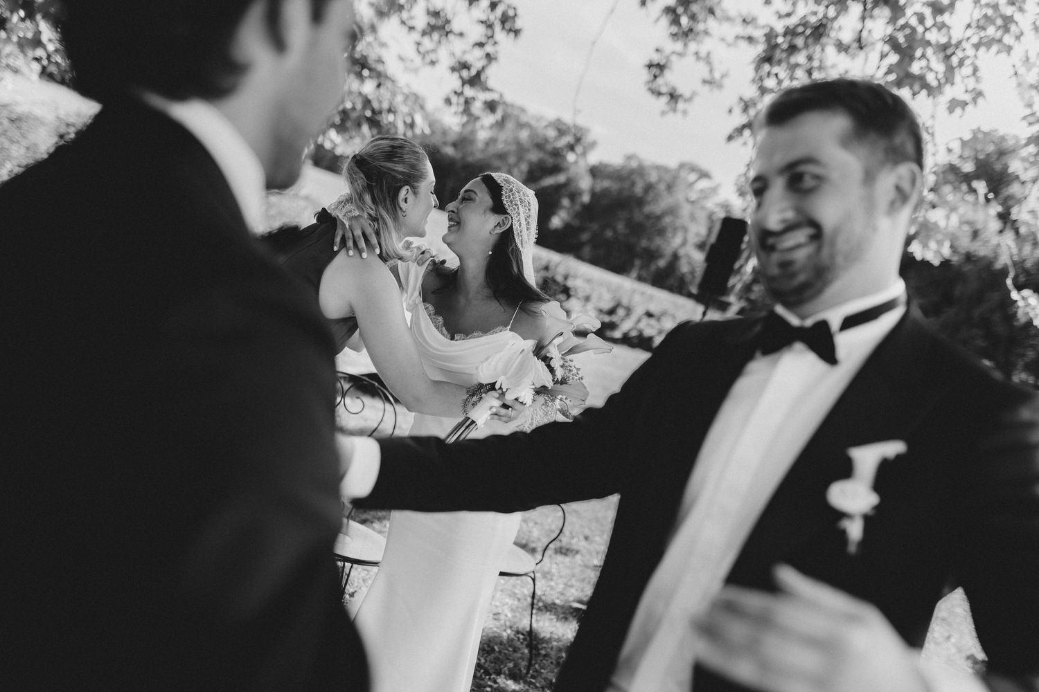 Intimate bridal couple exchange during a sun-drenched ceremony at Domaine du Réveillon. A candid, film-inspired moment captured