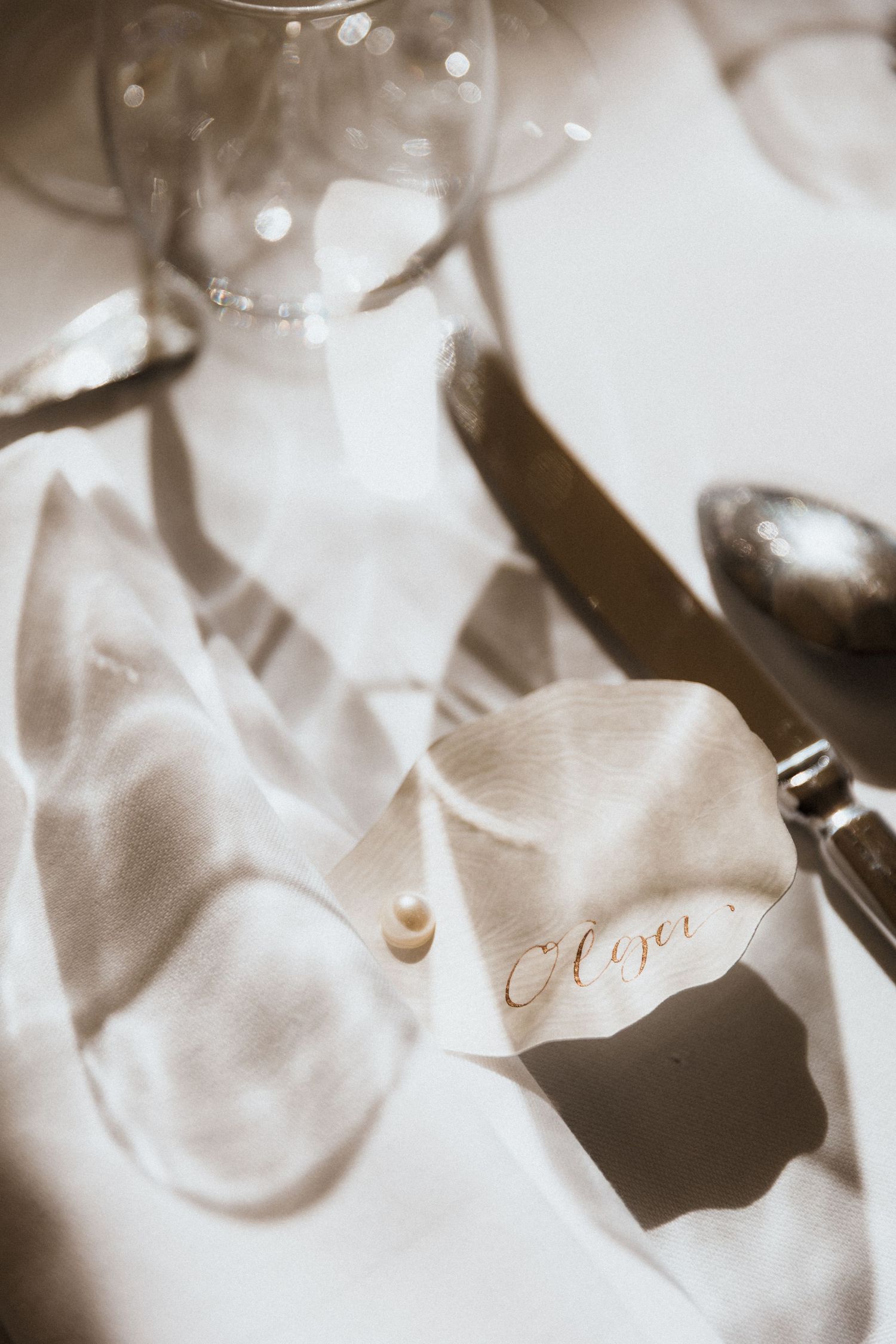 Soft focus close-up of elegant white place cards with calligraphy at a formal event setting.