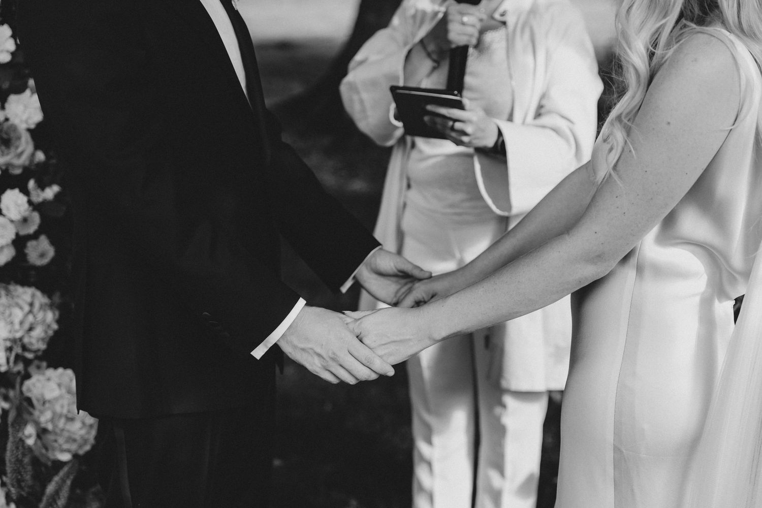 A black and white photo shows people in formal attire gathered at what appears to be a wedding reception.
