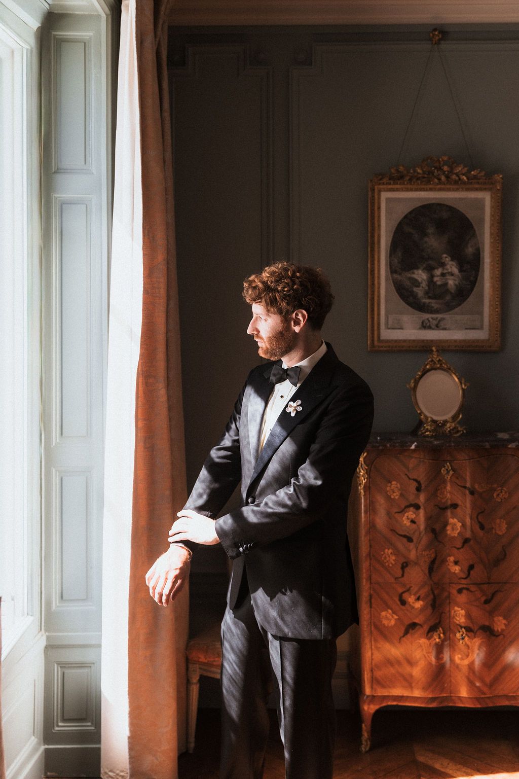 Elegant wedding portraits in a vintage room with ornate furniture and natural window light.