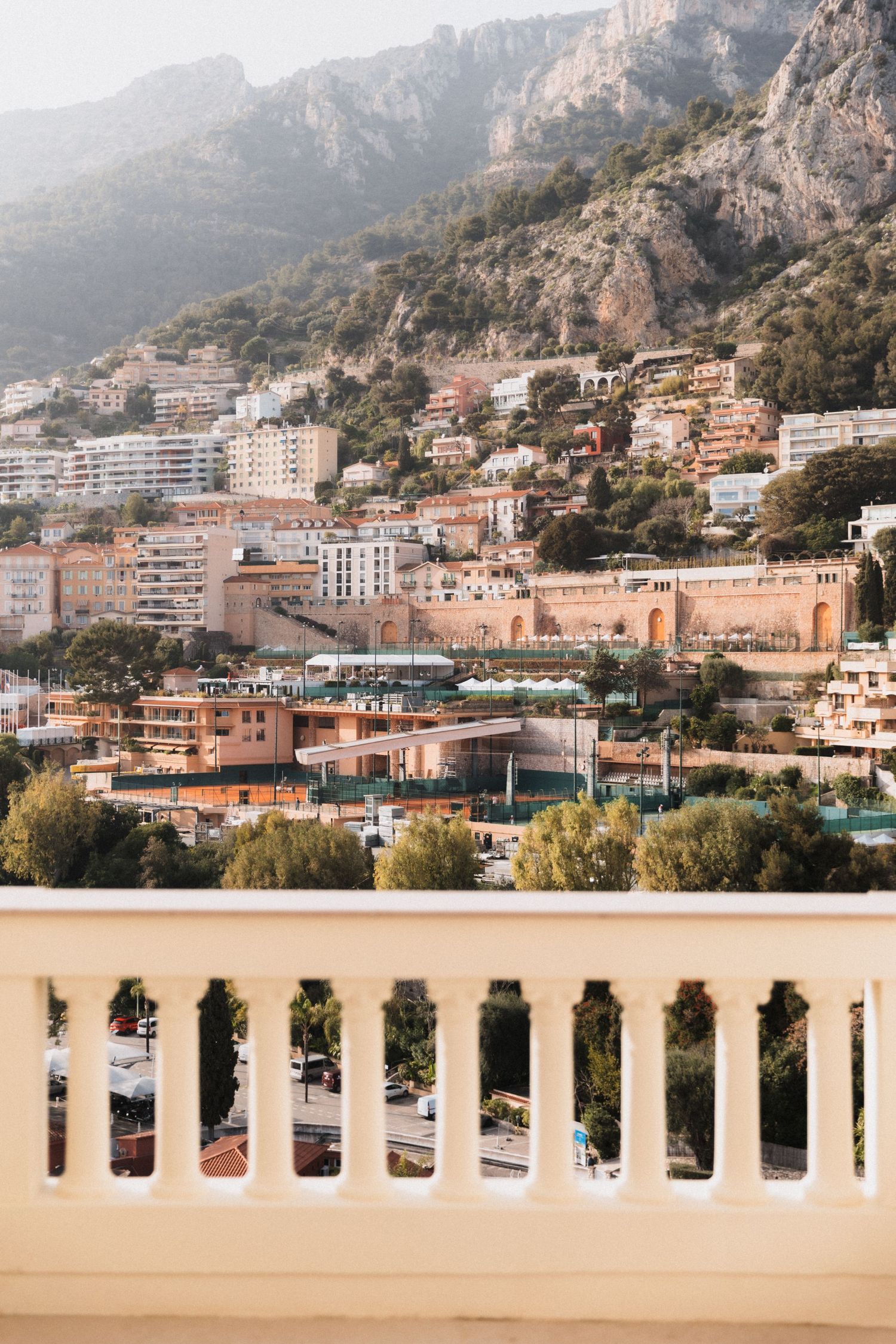 Villa La Vigie - Scenic view of Monaco hillside buildings and mountains from elegant white balustrade terrace in sunlight.