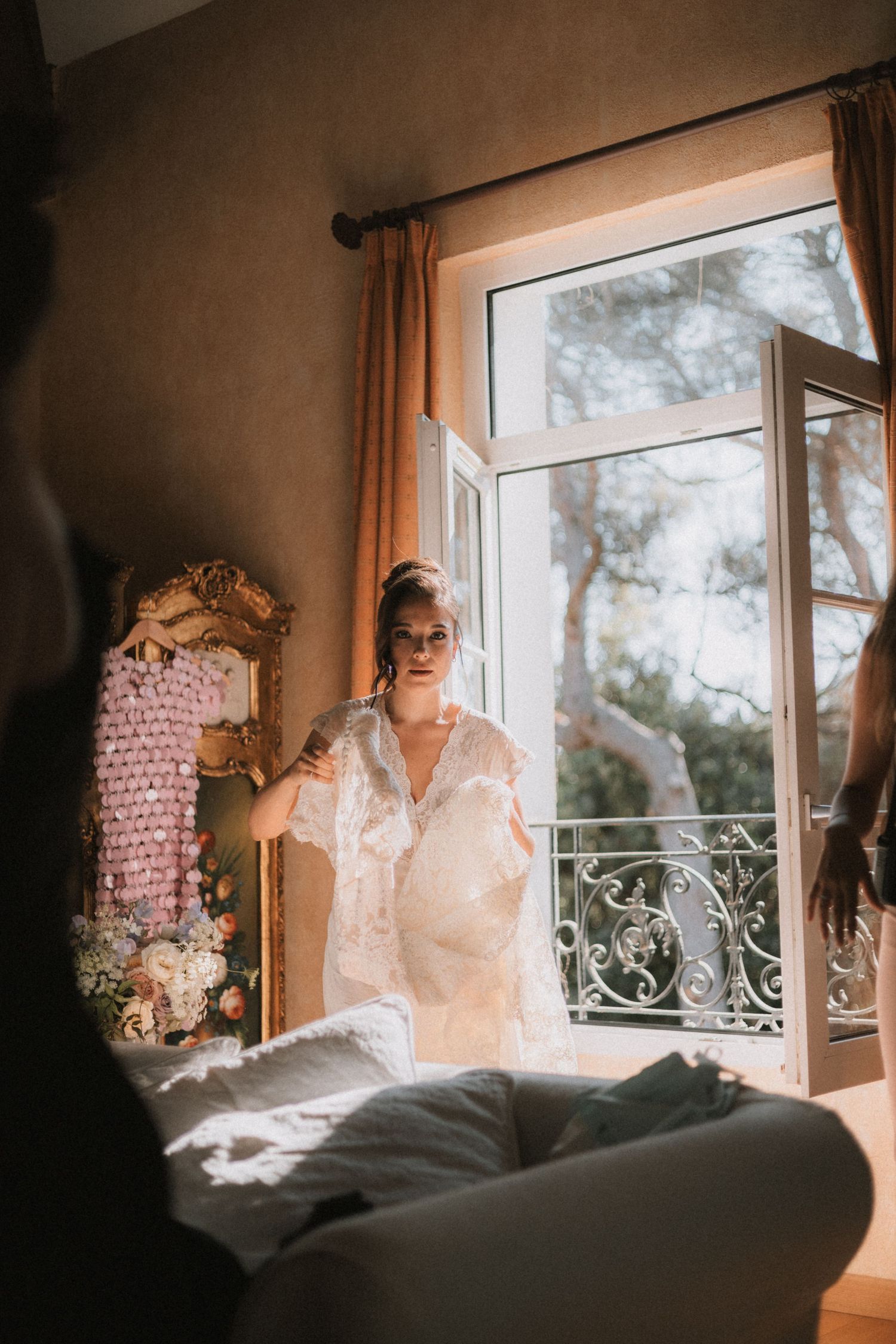 Sunlit bridal preparations by a window with delicate lace details and soft morning light.