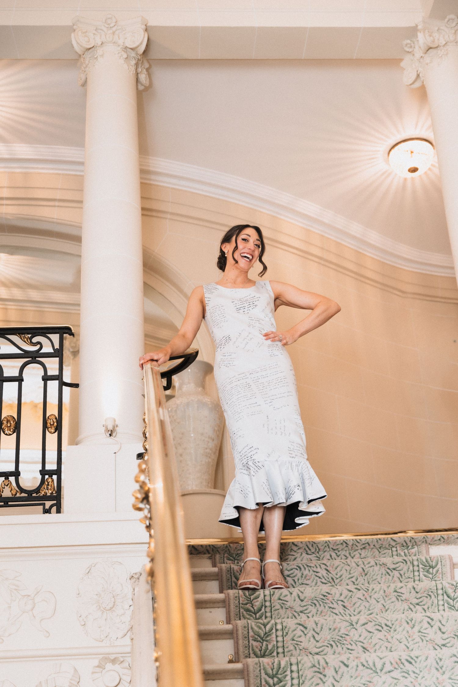 White lace wedding dress photographed in an elegant room with classical columns and ornate decor.