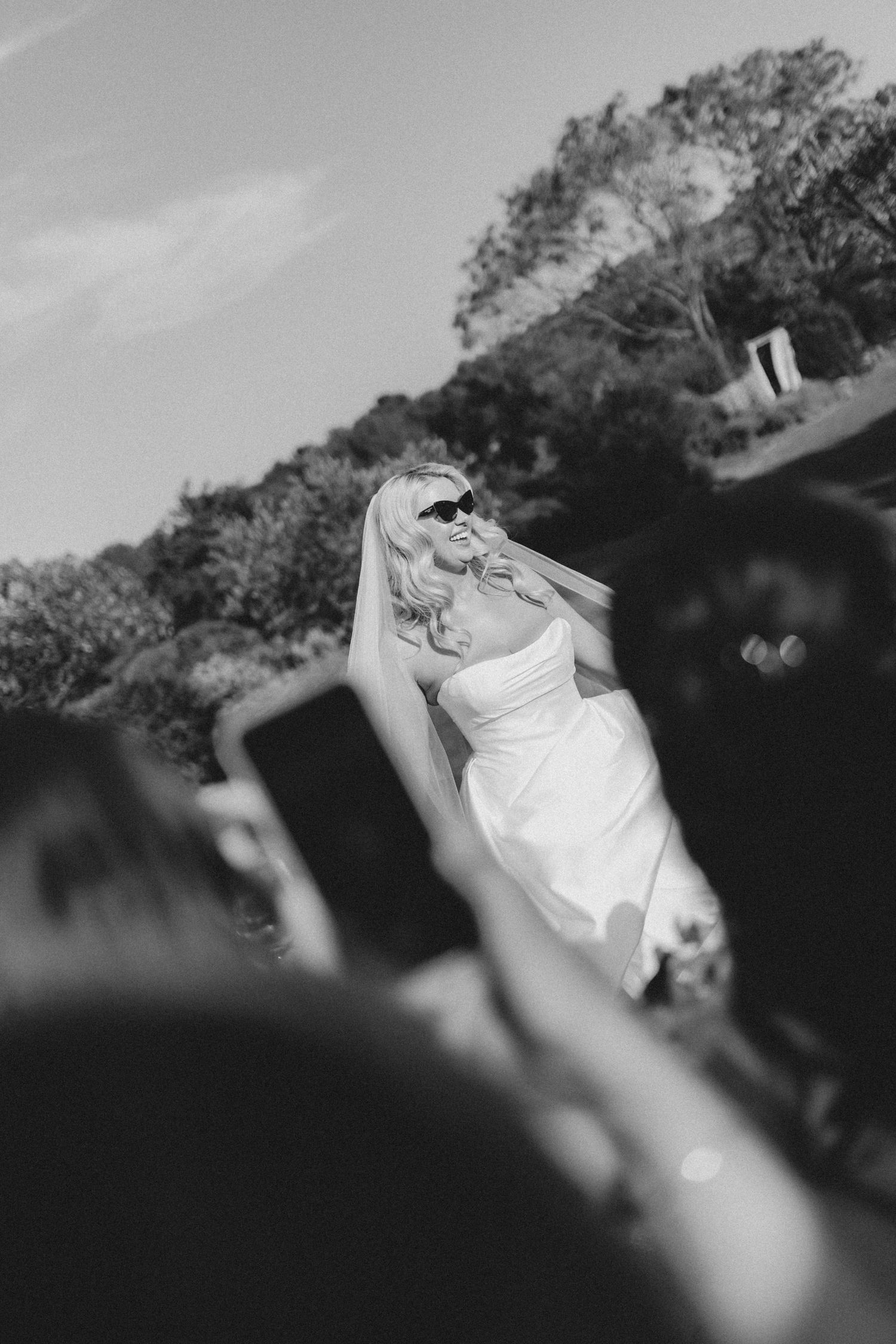 Black and white photo series captures a person in white dress spinning and twirling outdoors against a blurred background.