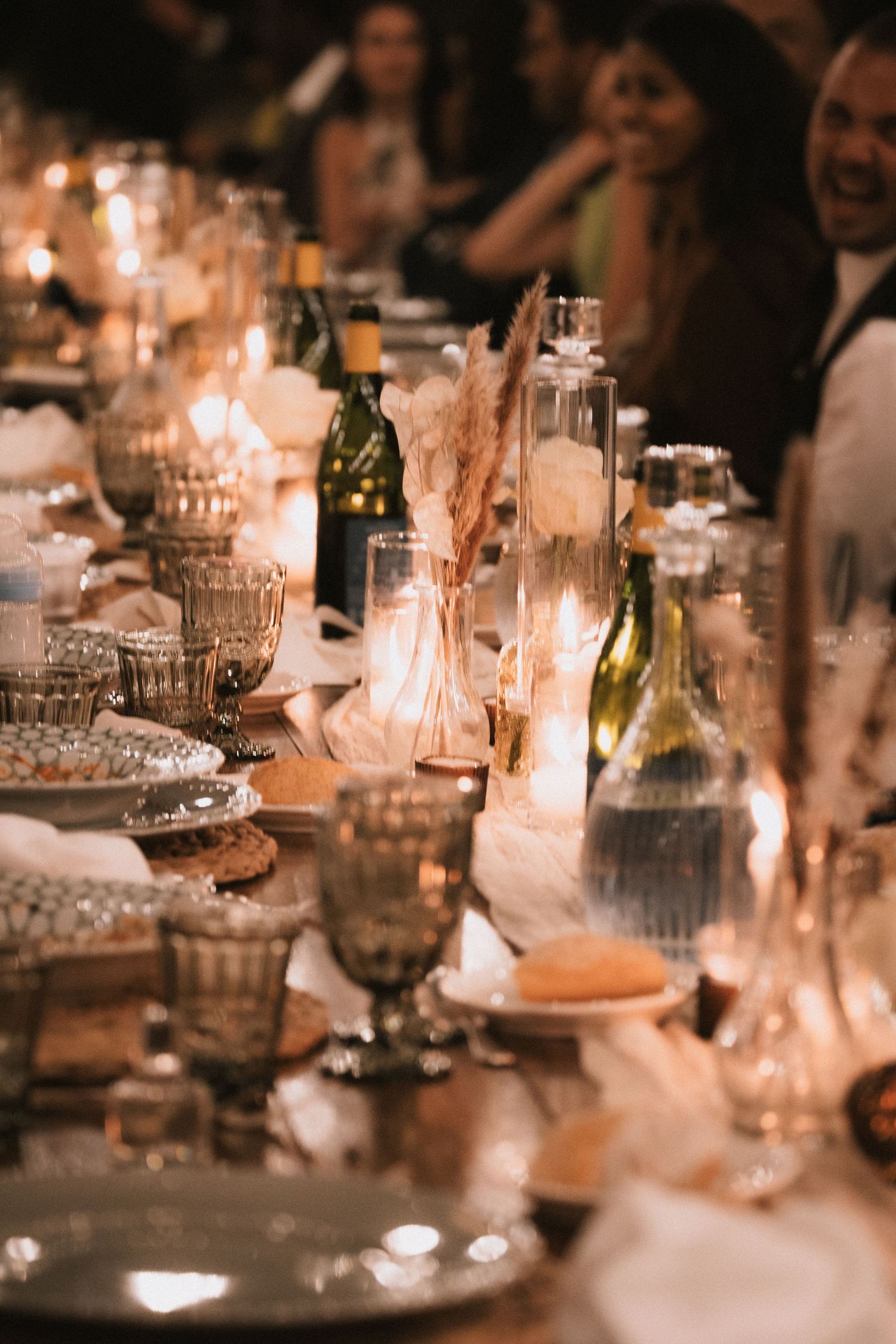 Candlelit wedding reception table with elegant glassware and place settings creating a romantic ambiance.