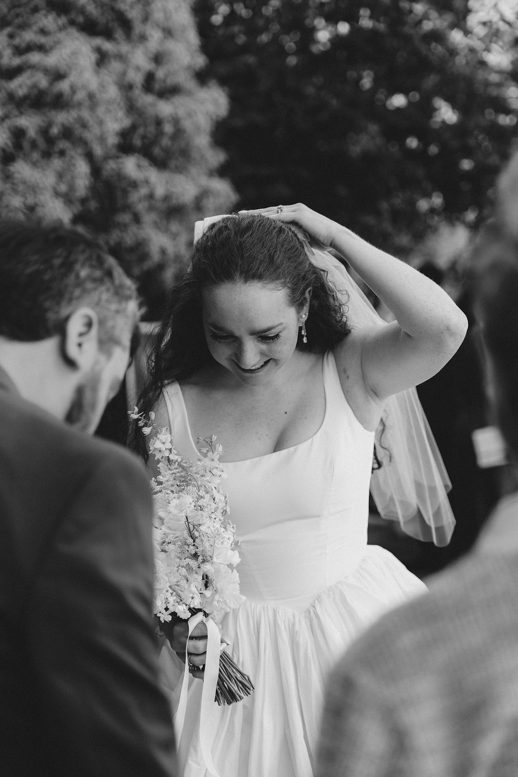 A series of black and white photos showing a bride in a white dress preparing for her wedding ceremony.