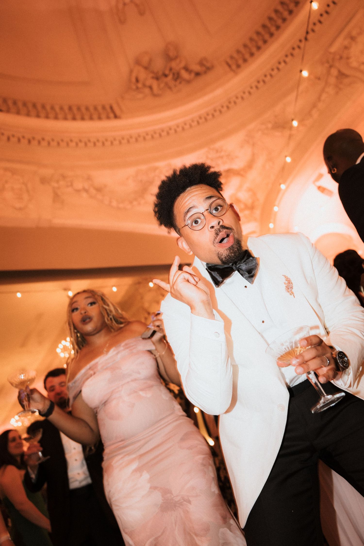 Wedding reception dance party with guests in formal attire.
