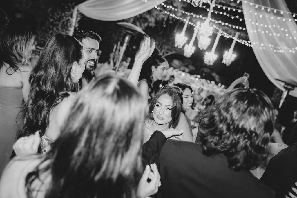 Black and white wedding reception photos showing couples dancing and celebrating under twinkling lights.