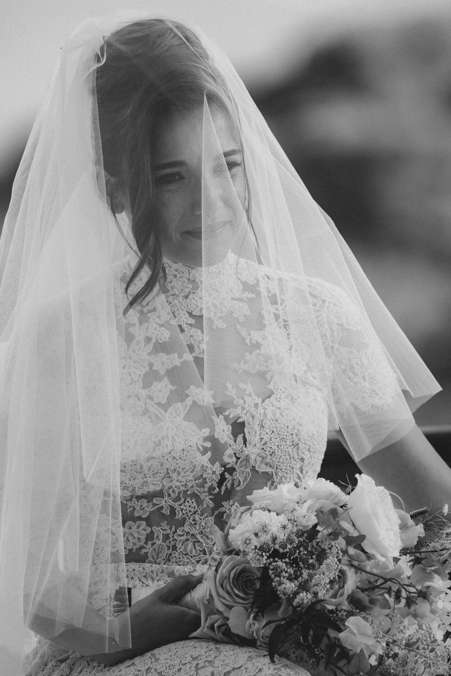 Elegant bridal portrait series featuring intricate lace veil and white floral bouquet details in black and white.