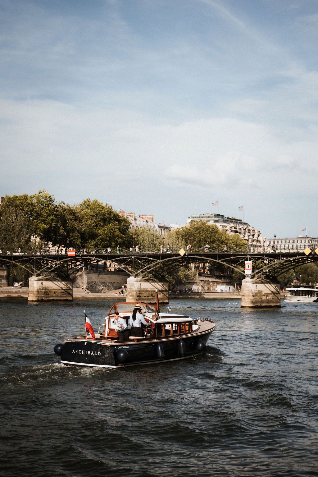 Romantic Paris elopement: Le Bateau Français cruising the Seine past Notre Dame and historic bridges. Private wedding cruise views