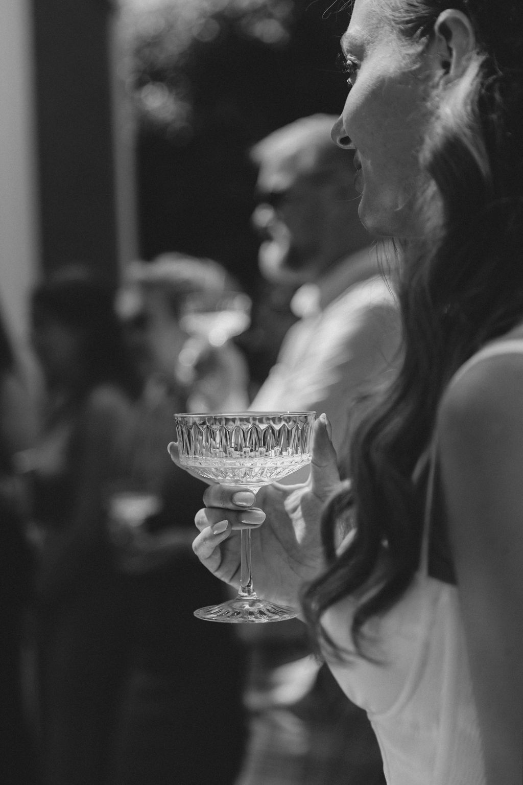 A series of black and white photographs showing people holding clear glass aligners or dental retainers.