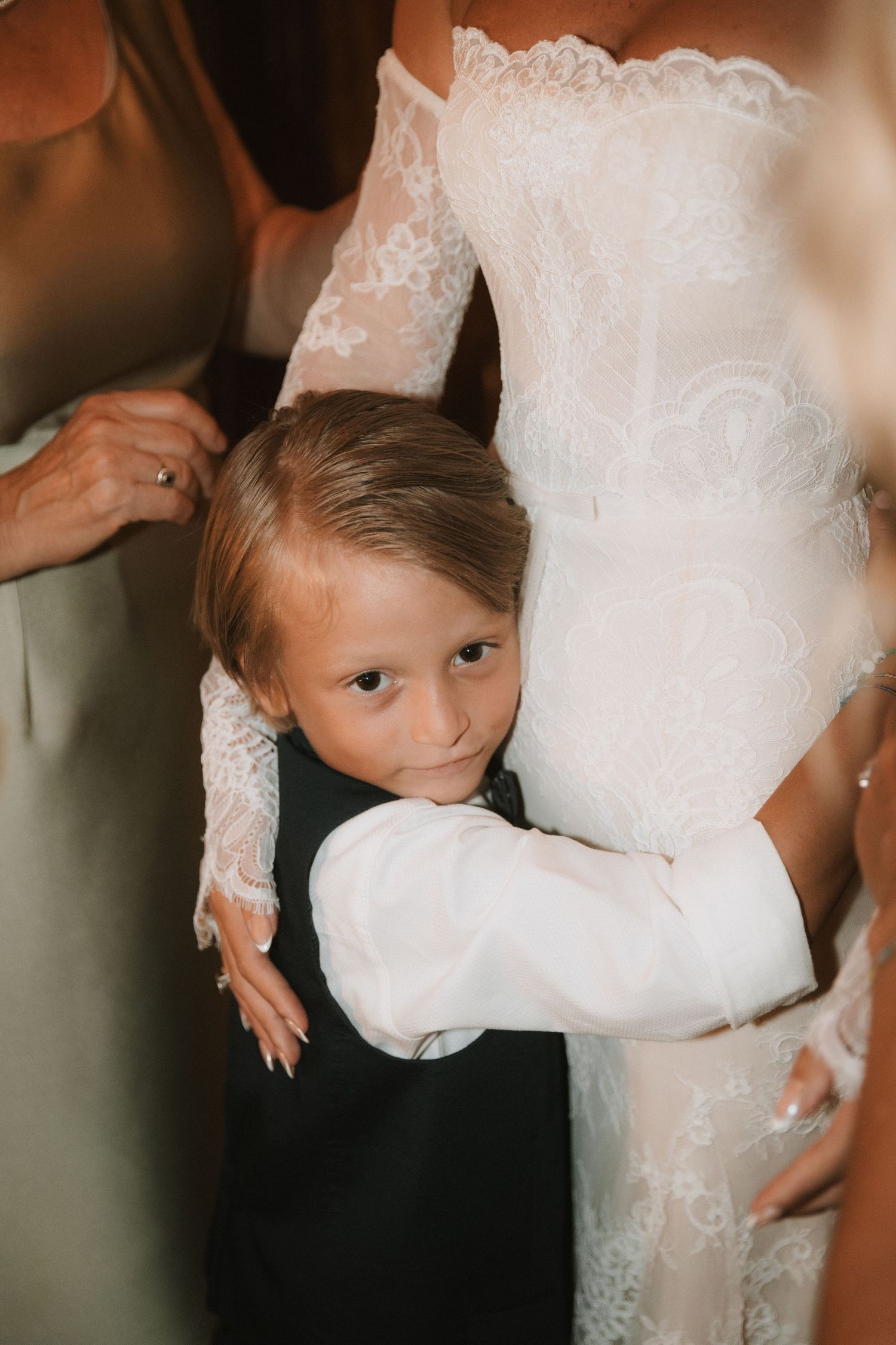 Close-up details of a white lace wedding dress with delicate embroidery patterns and sheer long sleeves.