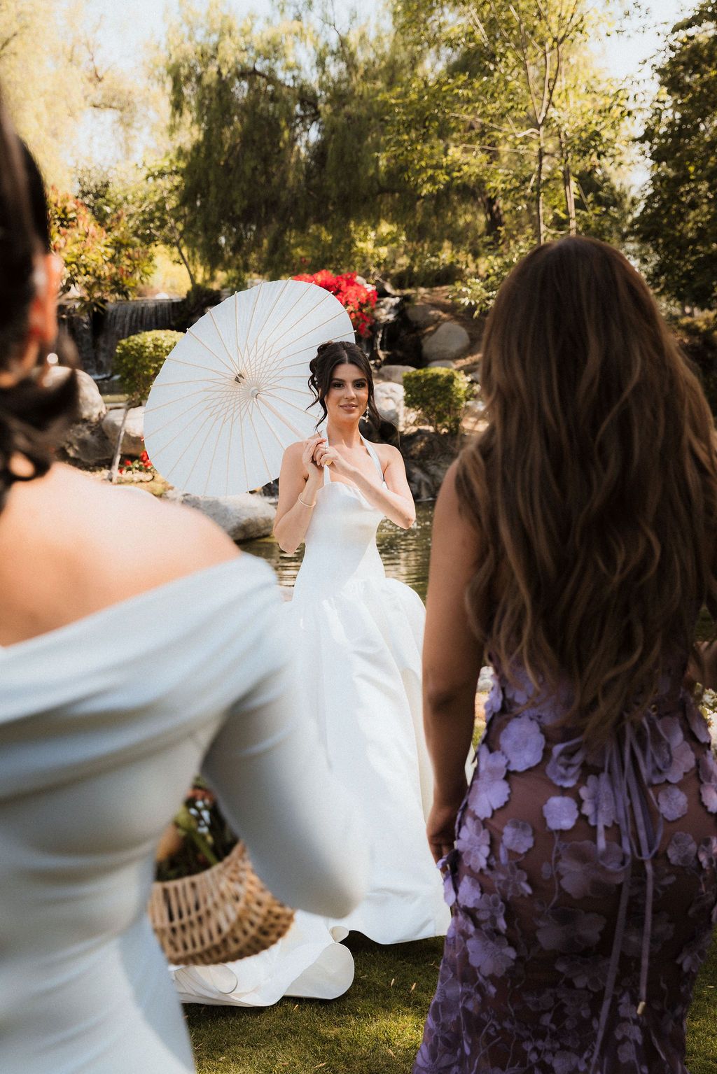 Bride in an elegant white wedding dress with a delicate parasol at Coyote Hills Golf Club, Fullerton, CA—a perfect garden wedding scene