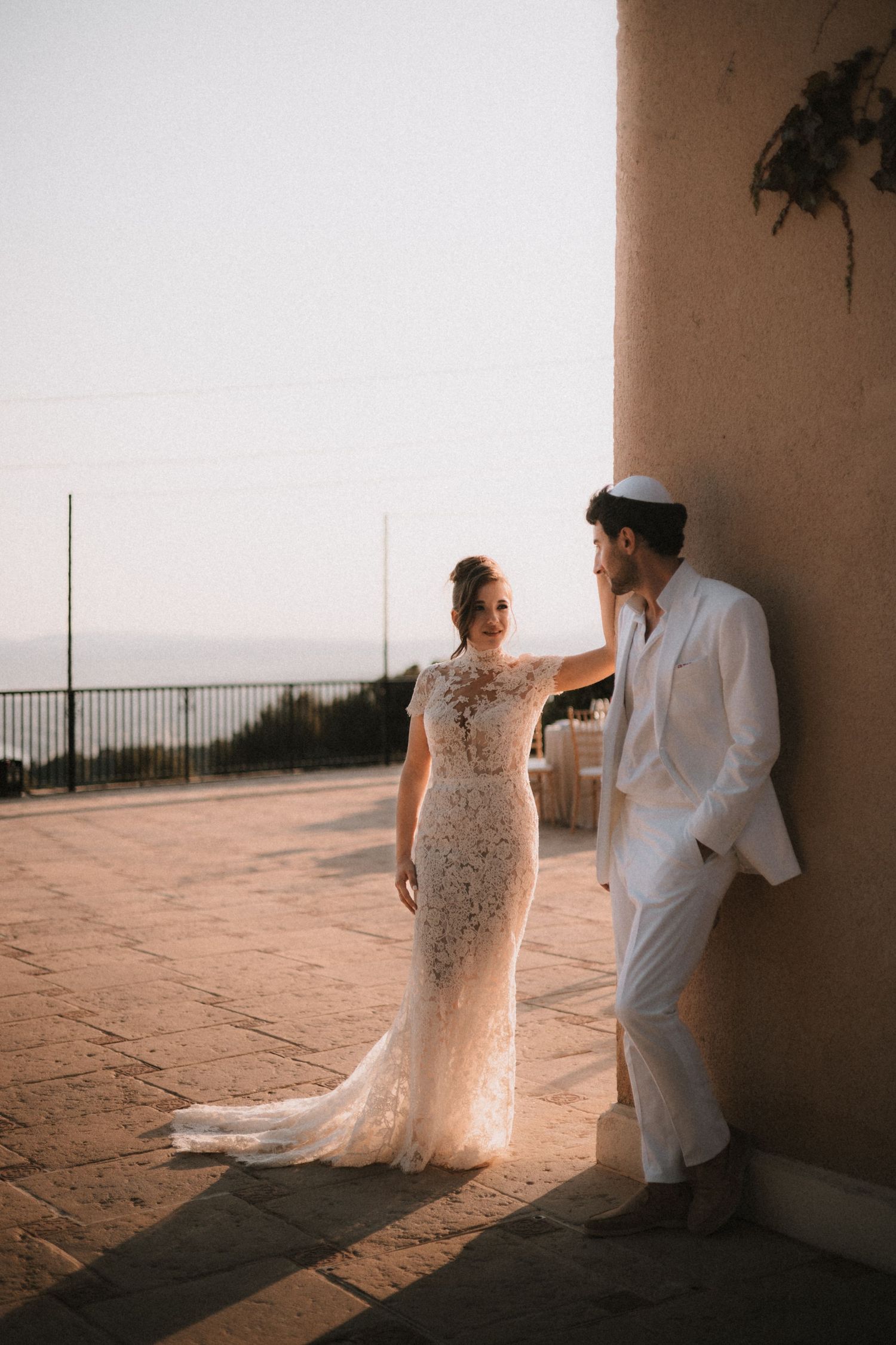 Romantic sunset wedding portraits captured in a Mediterranean-style corridor with soft golden light.
