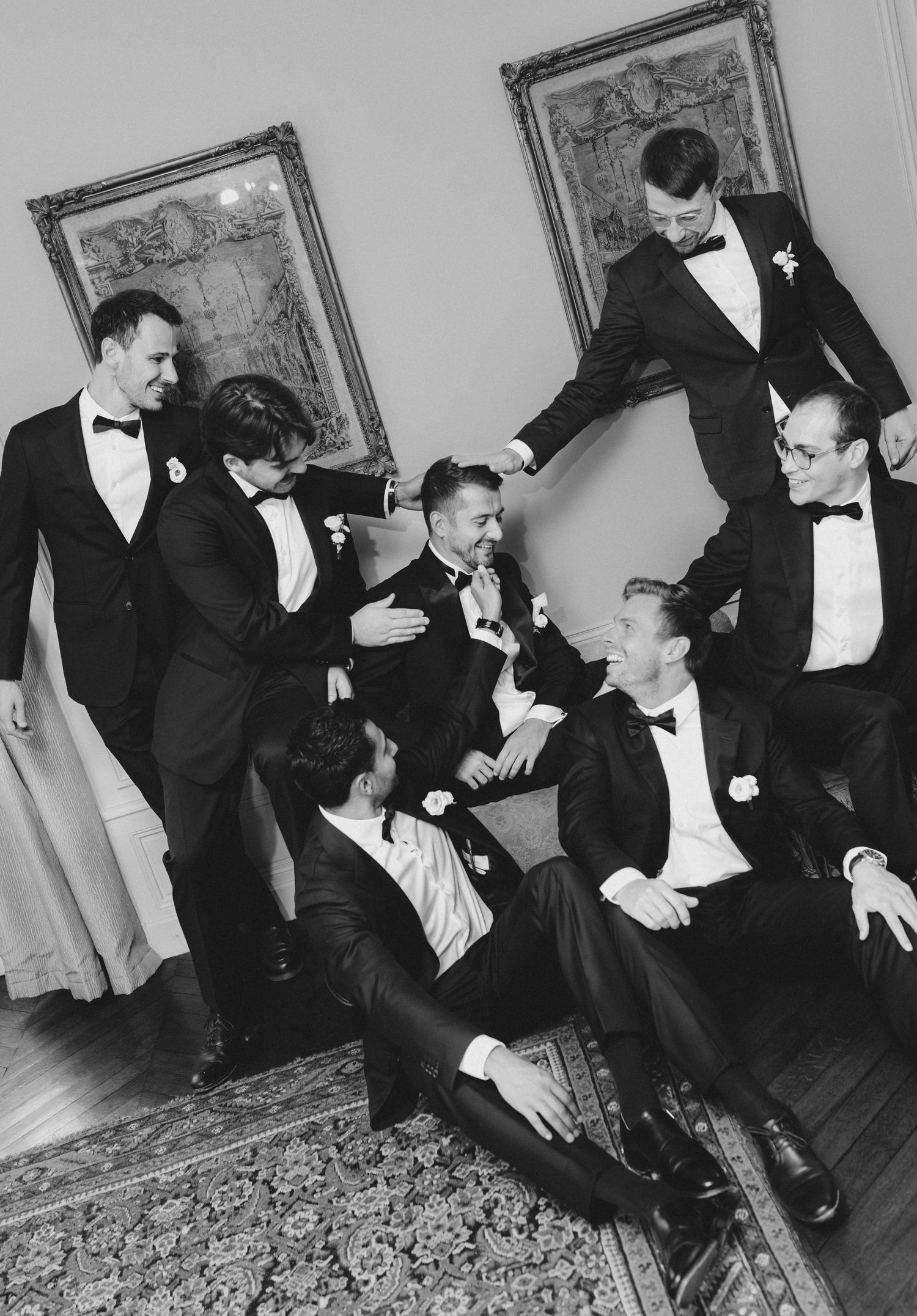 A series of black and white photos showing people in formal attire interacting at an elegant indoor gathering.
