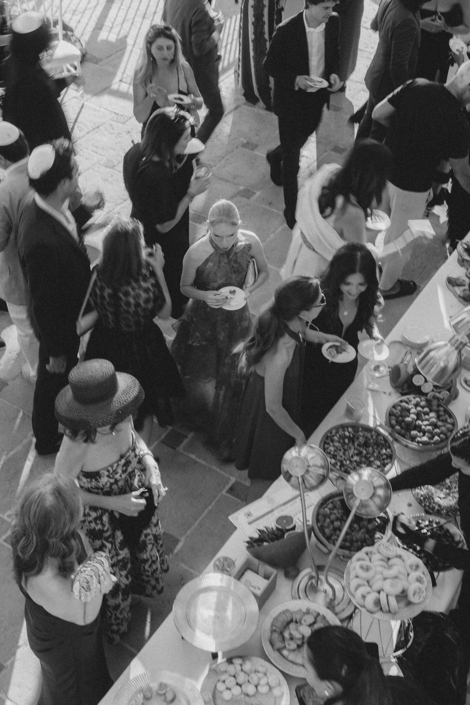 Aerial view of wedding reception buffet with guests gathering around food tables.