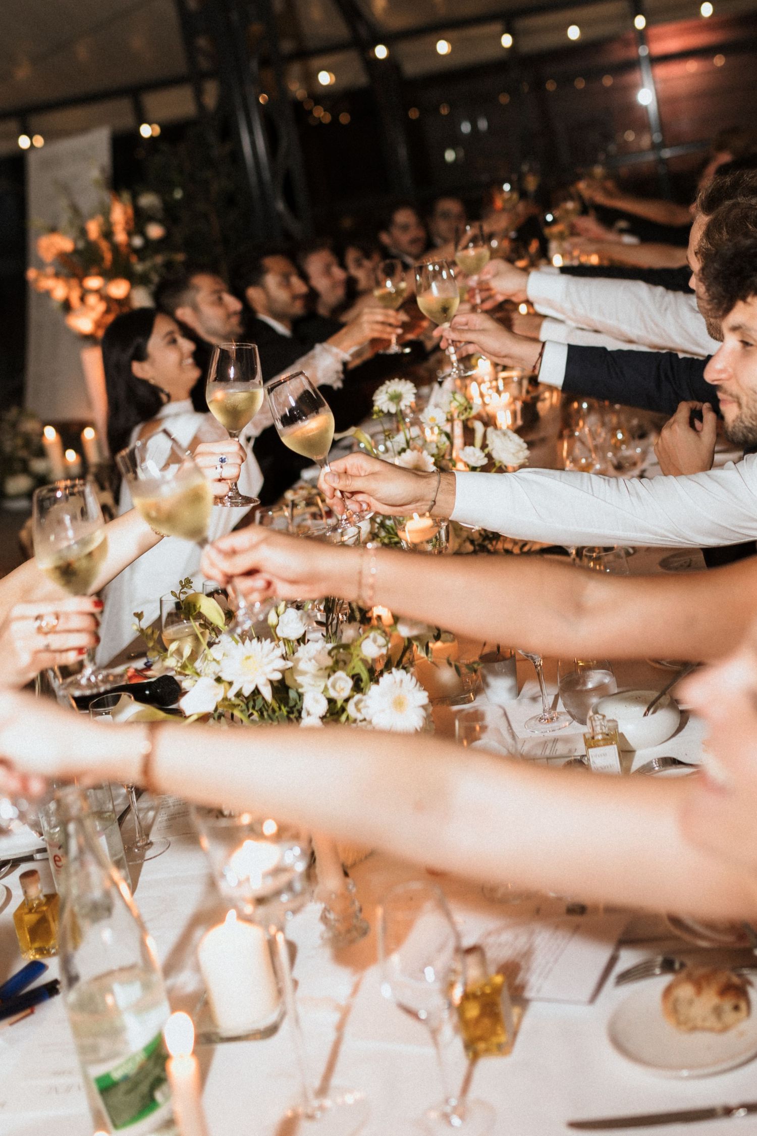 Wedding reception table settings with glowing candles and elegant floral centerpieces create a romantic atmosphere.