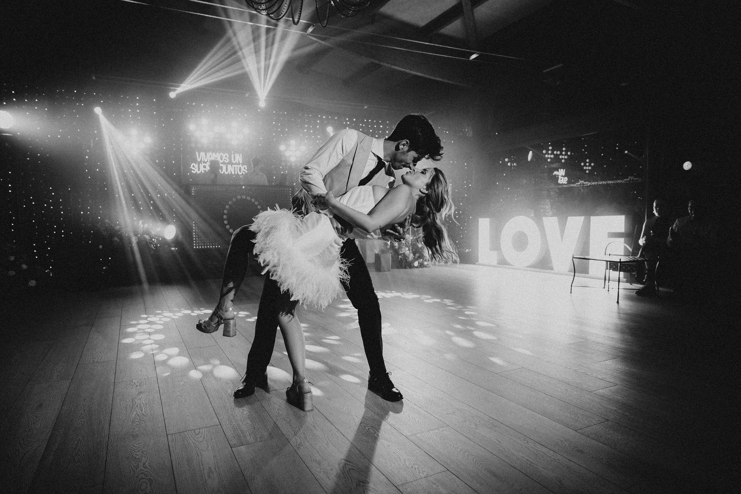 Black and white photos of people ice skating on a rink with glowing lights and a LOVE sign in the background. Masia Les Casotes.