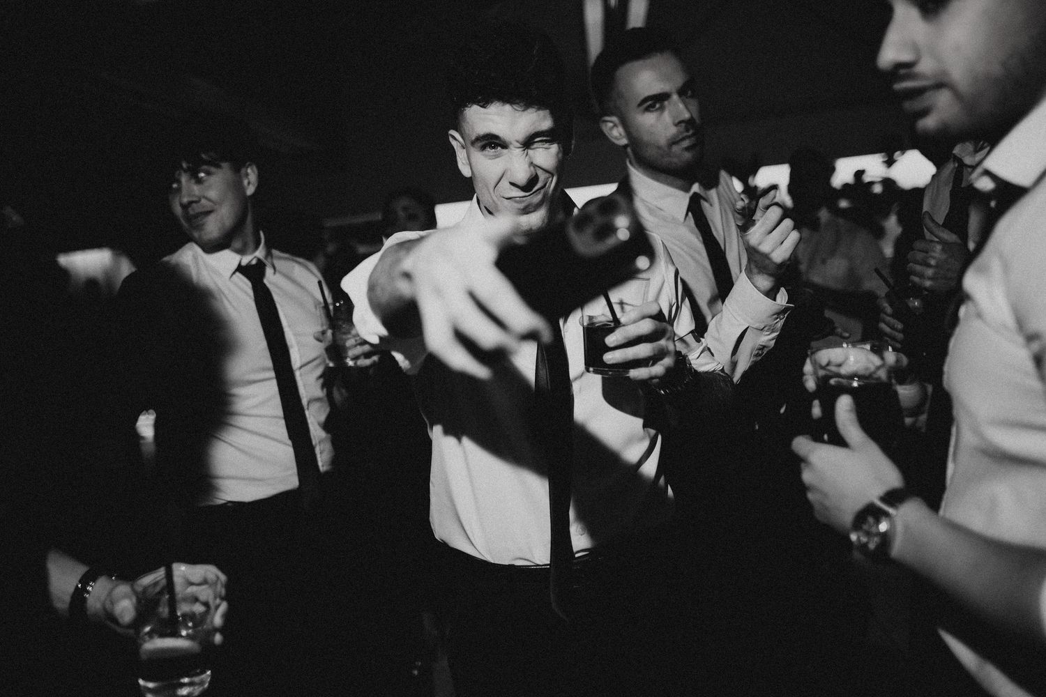Black and white photos of people dancing and celebrating at a lively party or nightclub event. Wedding in Jardins del Tancat.