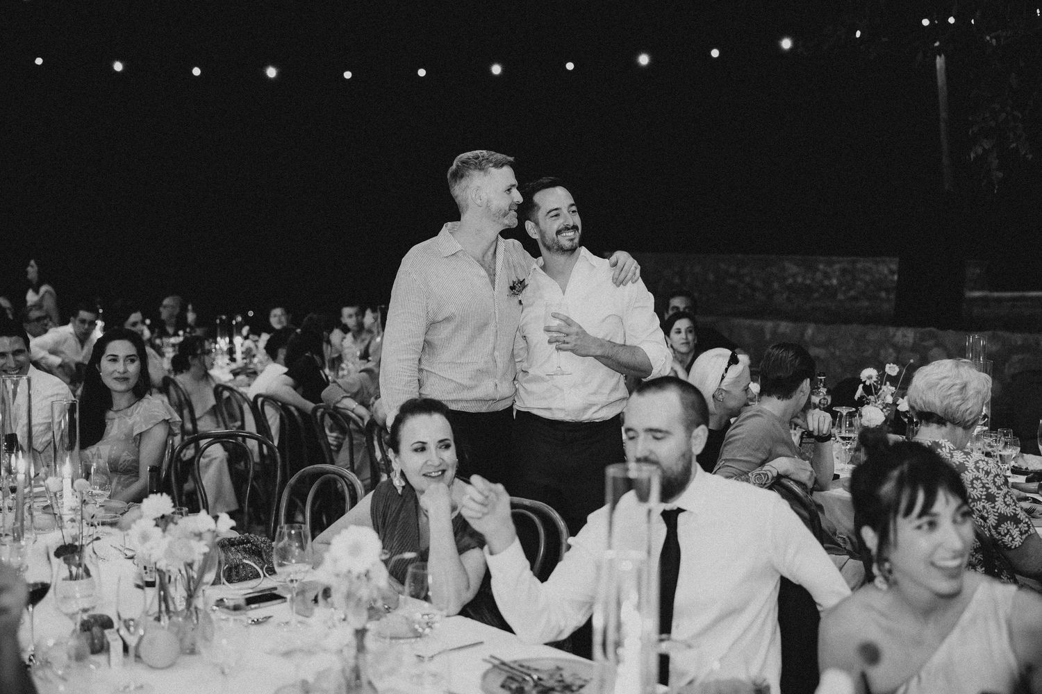 Black and white candid photos of guests enjoying a wedding reception with dancing and dining. Mas de l'Illa.
