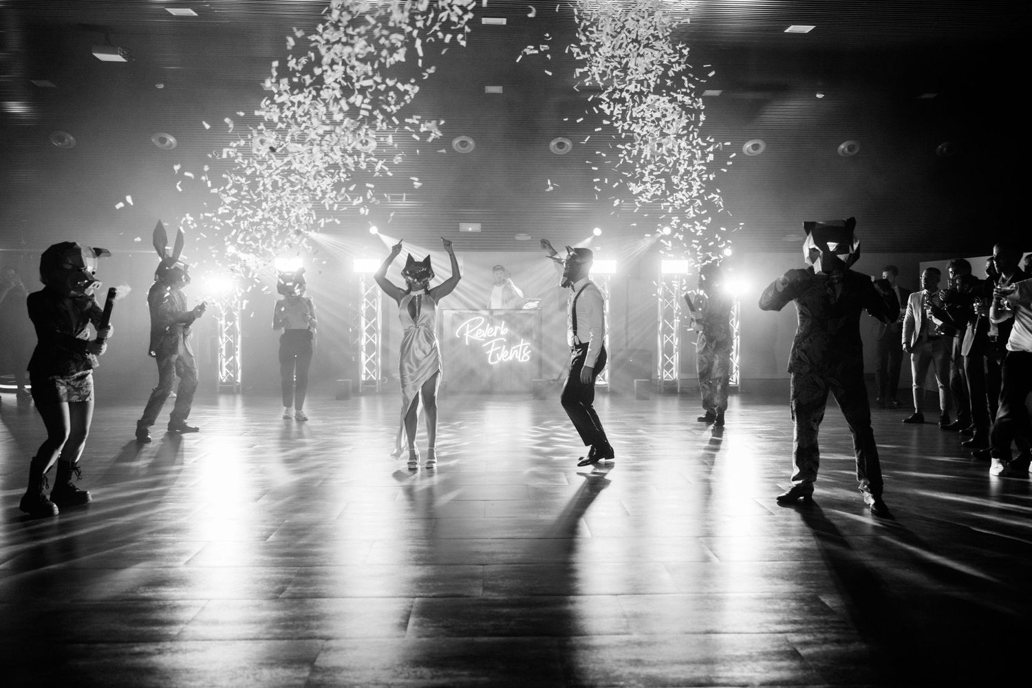 Silhouettes of dancers on a dark dance floor with sparkling confetti falling under dramatic lighting. Wedding in Villa Retiro.
