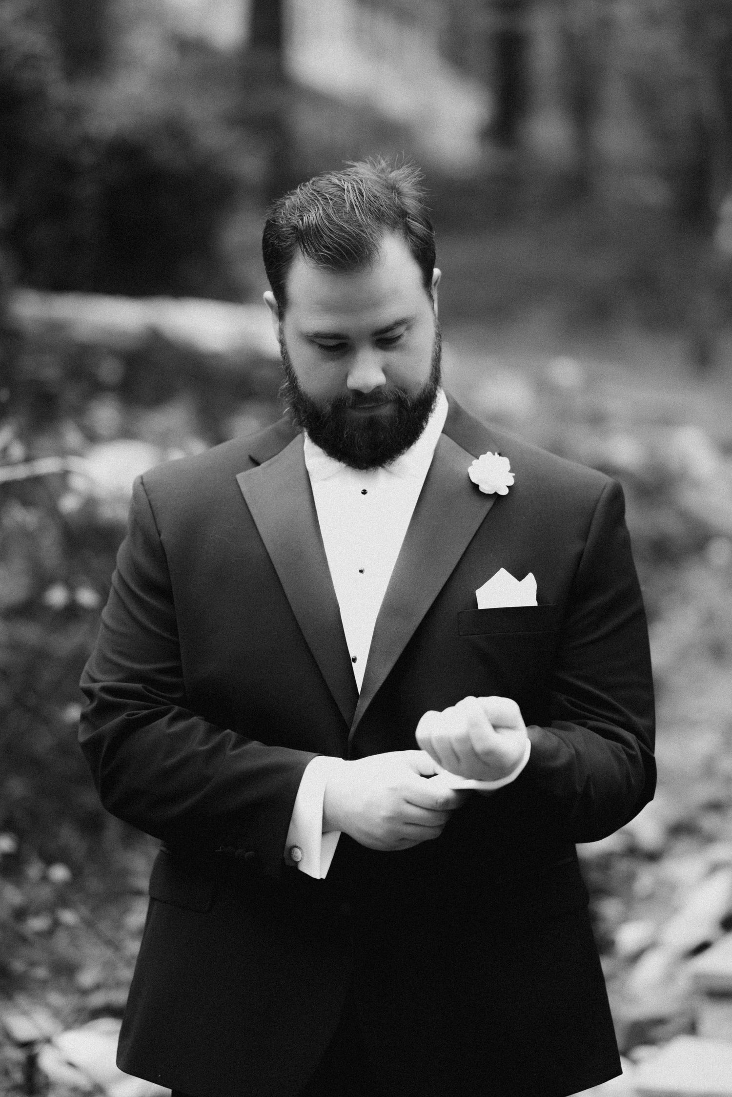 A groom in a black tuxedo checks his watch in a series of black and white photos.