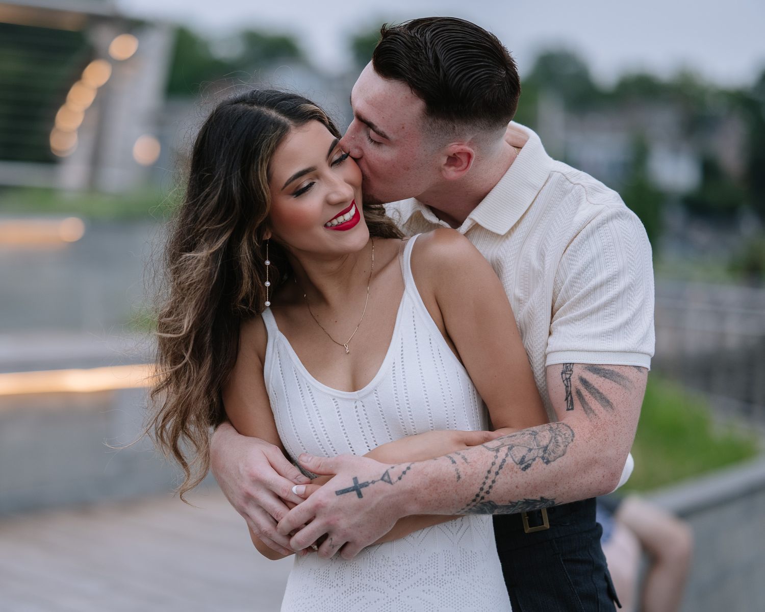 Couple laughing and embracing during sunset engagement session.