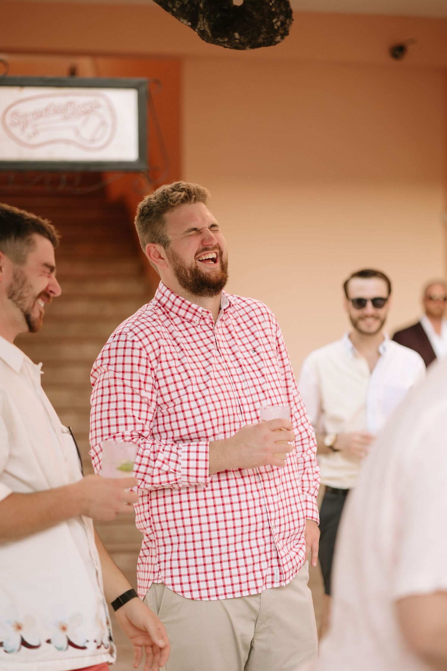 Guests in red and white checkered shirts enjoying a celebration at an indoor venue.