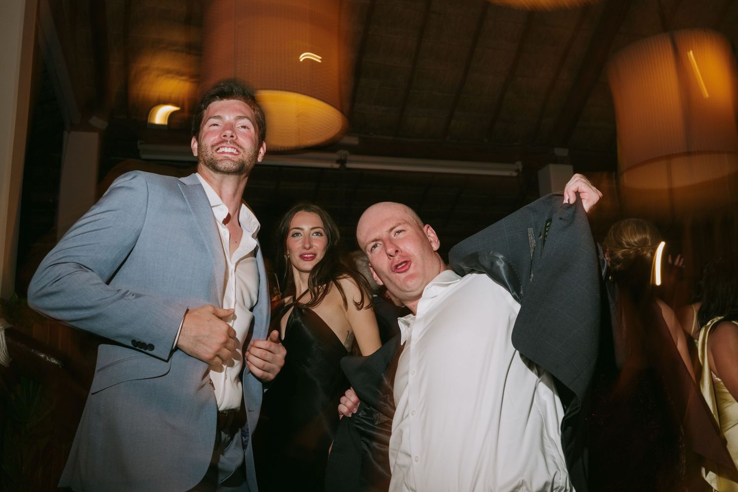 Wedding guests laughing and enjoying themselves at an evening reception.