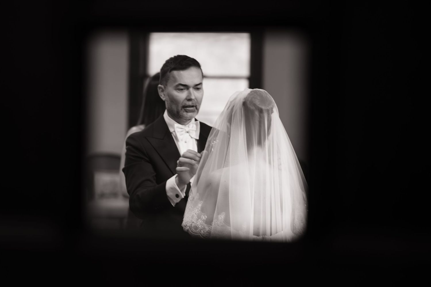 Black and white wedding photography captures intimate moments during a bridal preparation.