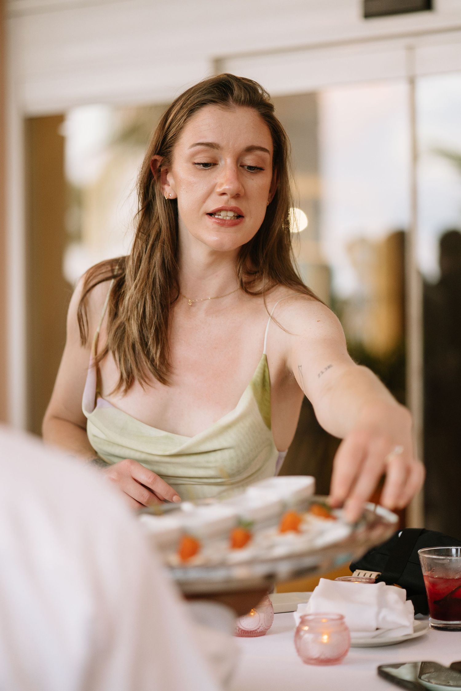 Someone enjoying tea and snacks at a bright, sunlit table with a casual, relaxed atmosphere.