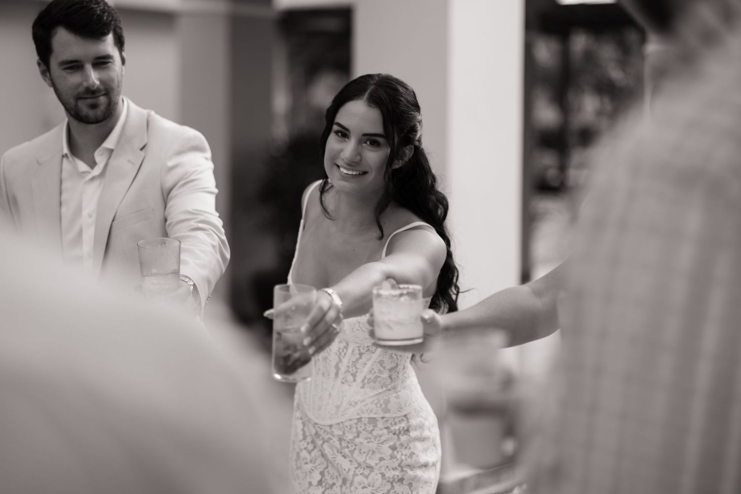 A couple dances together at a wedding reception in an elegant black and white photograph.