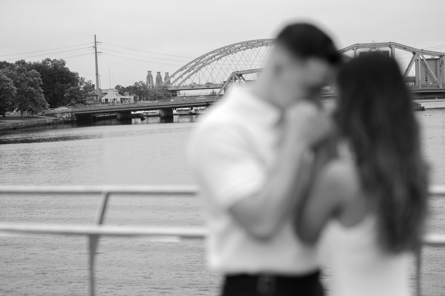 Black and white artistic photo of couple by waterfront.