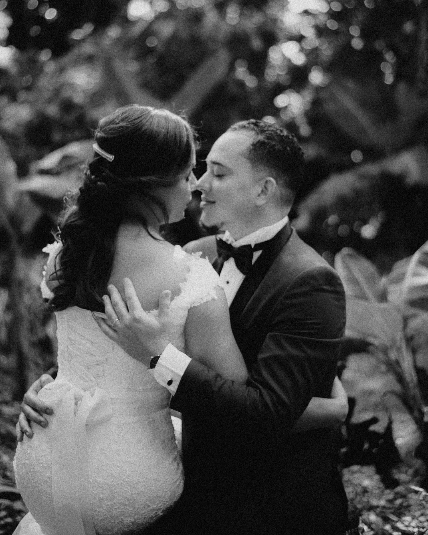 Romantic black and white wedding dance captured in soft bokeh lighting.