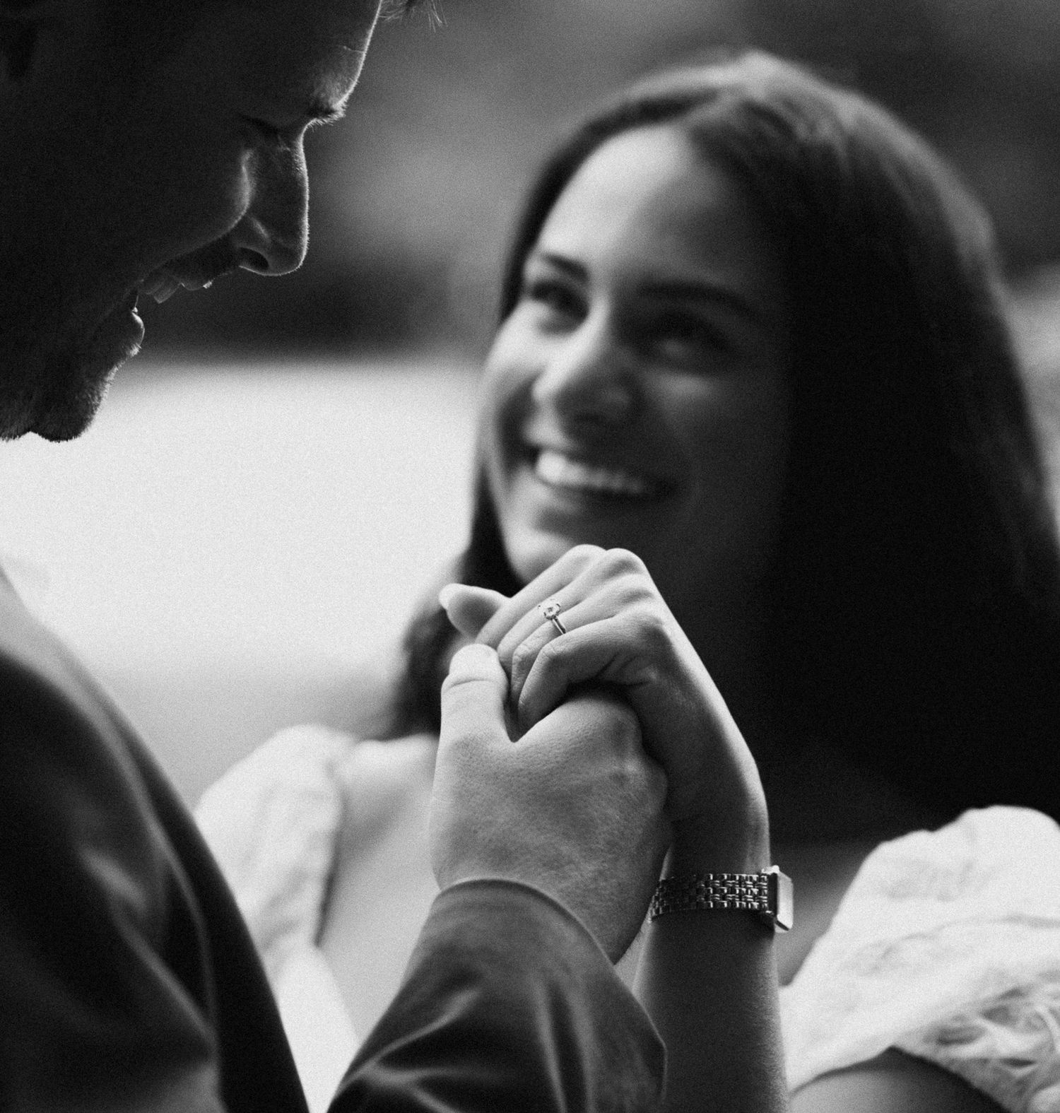 Black and white candid shot of a couple sharing an intimate moment.