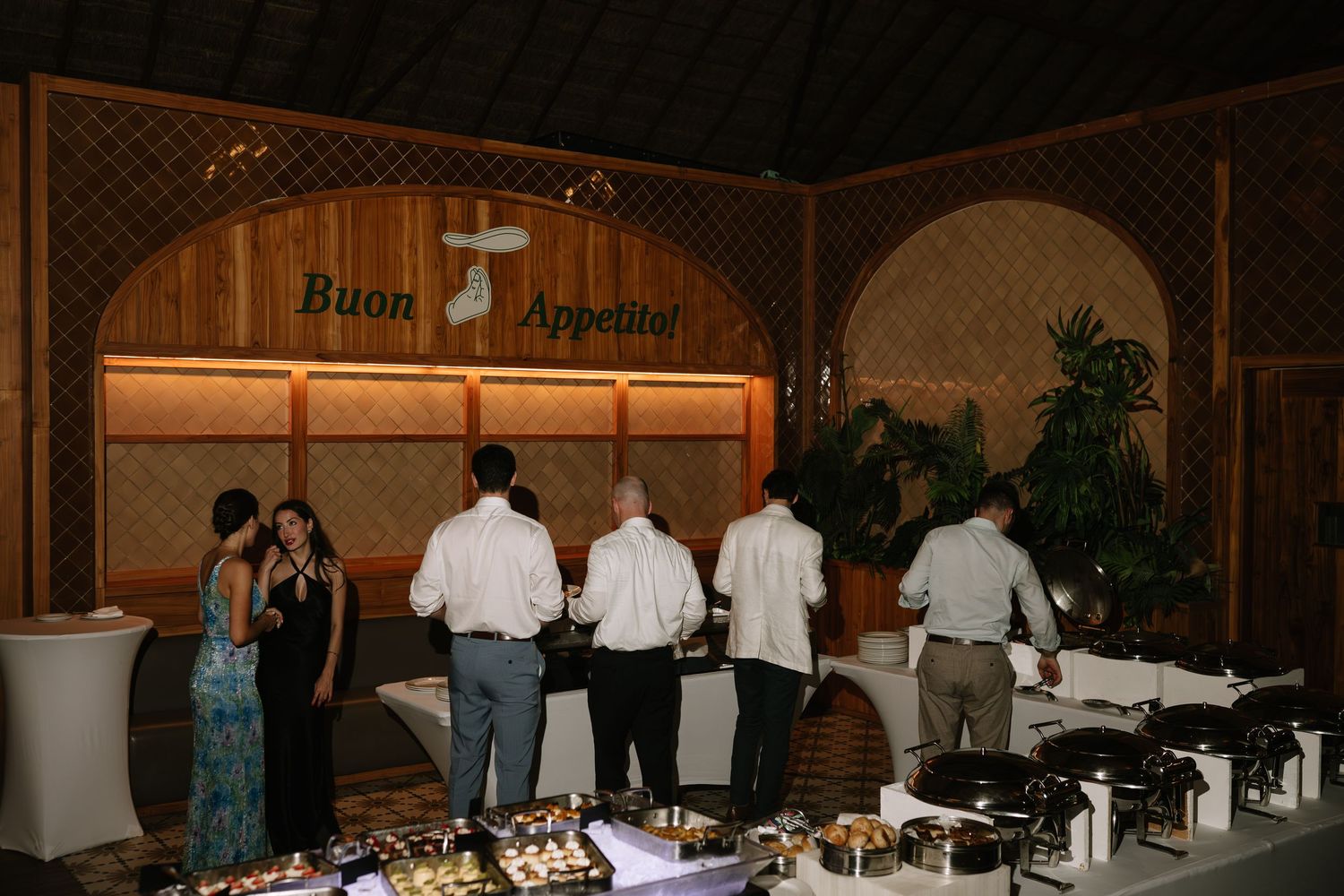 Long banquet table setup with white tablecloths and place settings in an elegant venue.