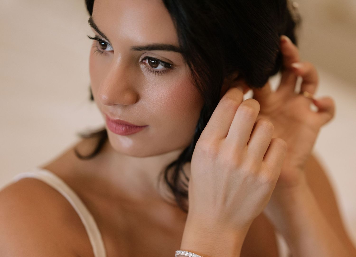 Close-up shots of a bride getting ready with elegant earrings and makeup for her wedding day.