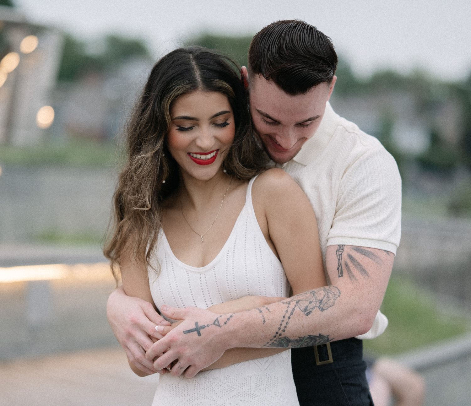 Couple sharing joyful embrace during outdoor photoshoot.