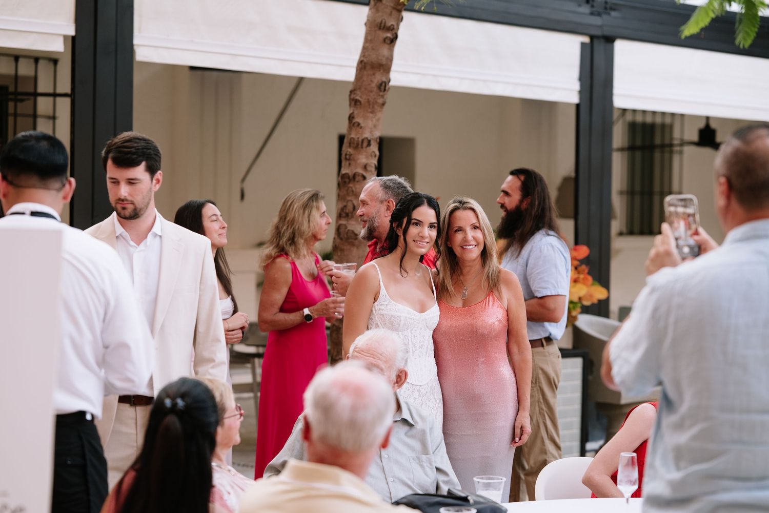 Wedding guests enjoying a lively celebration with dancing and socializing at an indoor reception venue.