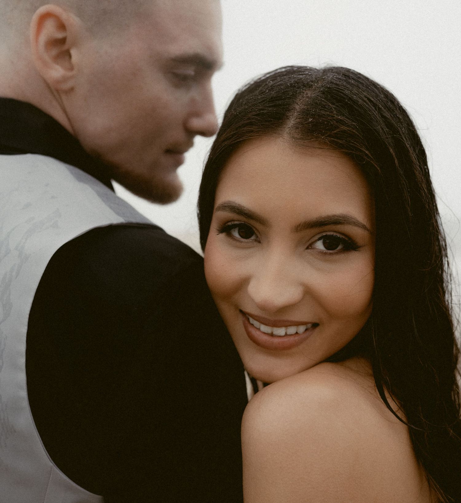 A romantic black and white portrait sequence showing a couple embracing and sharing tender moments.