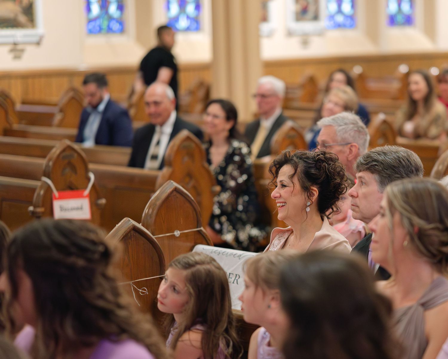 Wedding guests fill church pews during an emotional ceremony service.