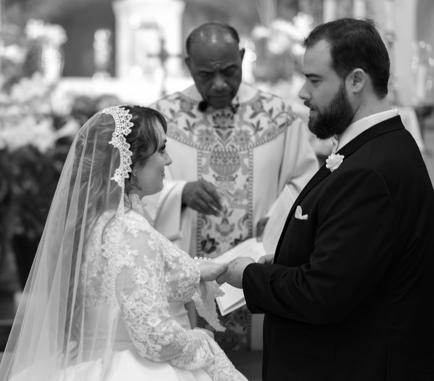 A wedding ceremony moment captured in black and white with elegant lace details.