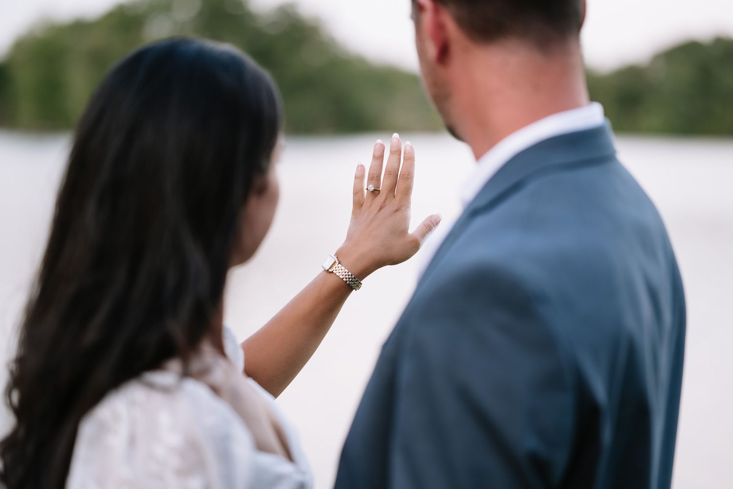 Romantic couple interacting between white marble columns during outdoor photo session.
