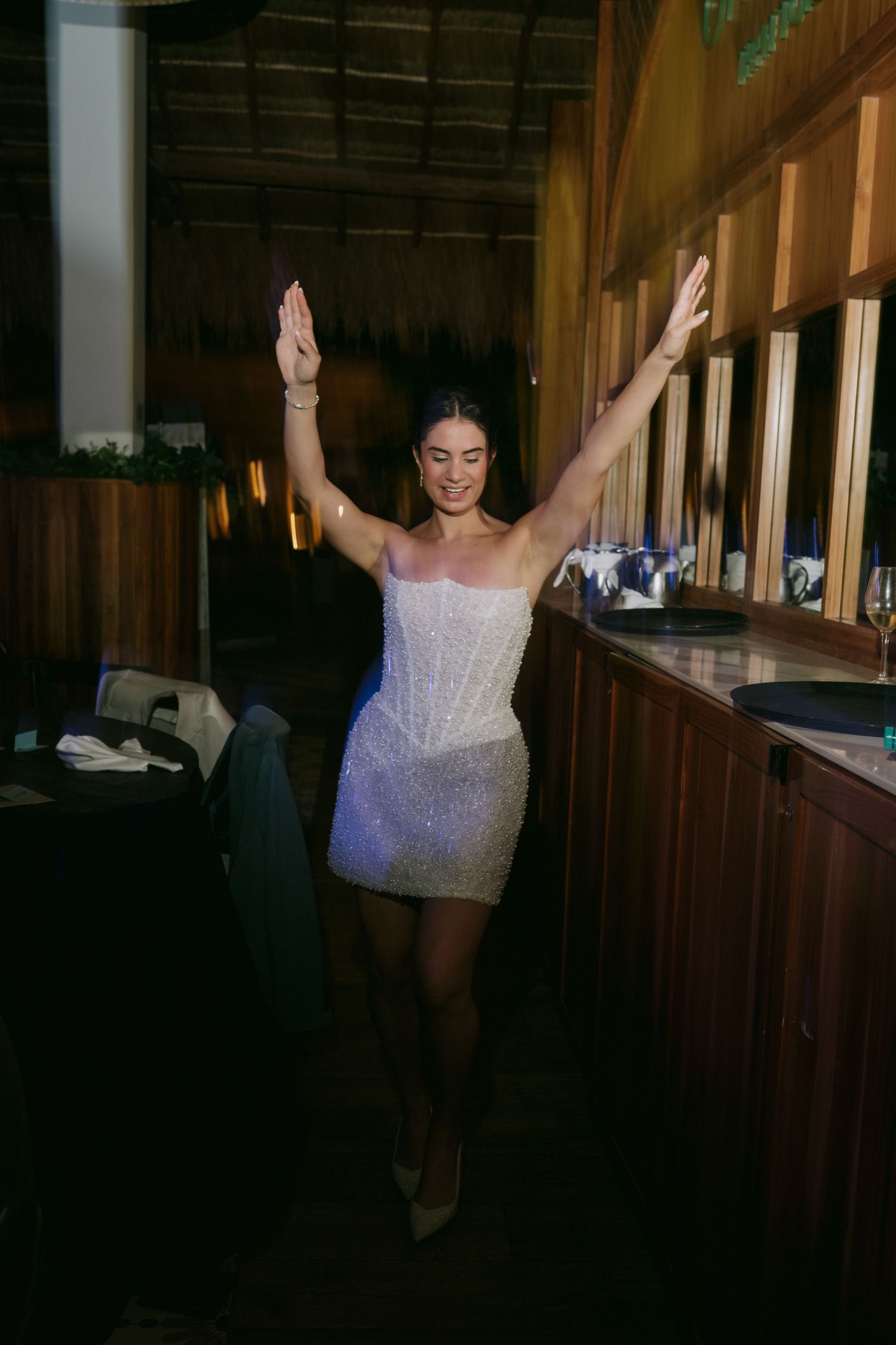 A celebratory moment captured in a dimly lit venue with raised arms.