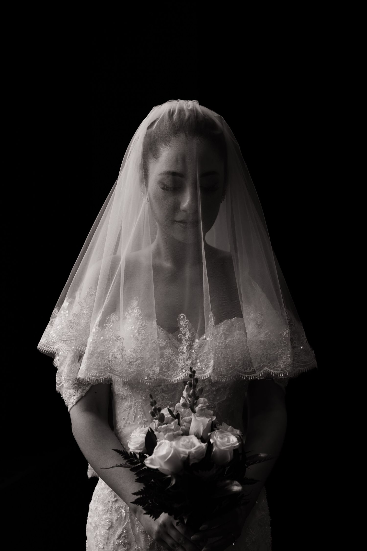 A black and white bridal series showing a veiled figure holding a bouquet against a dark background.