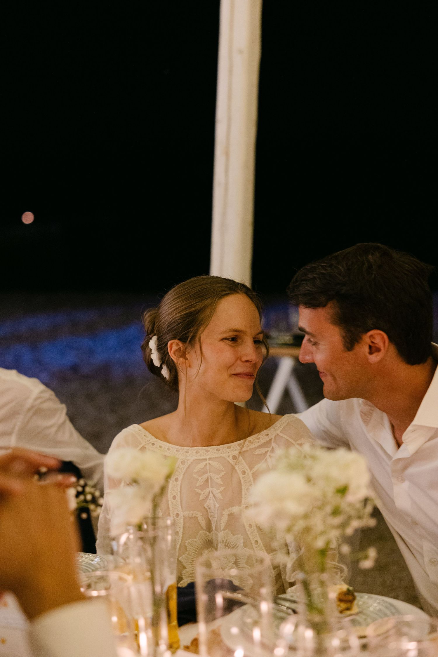 a crying bride looking at her husband on their wedding table