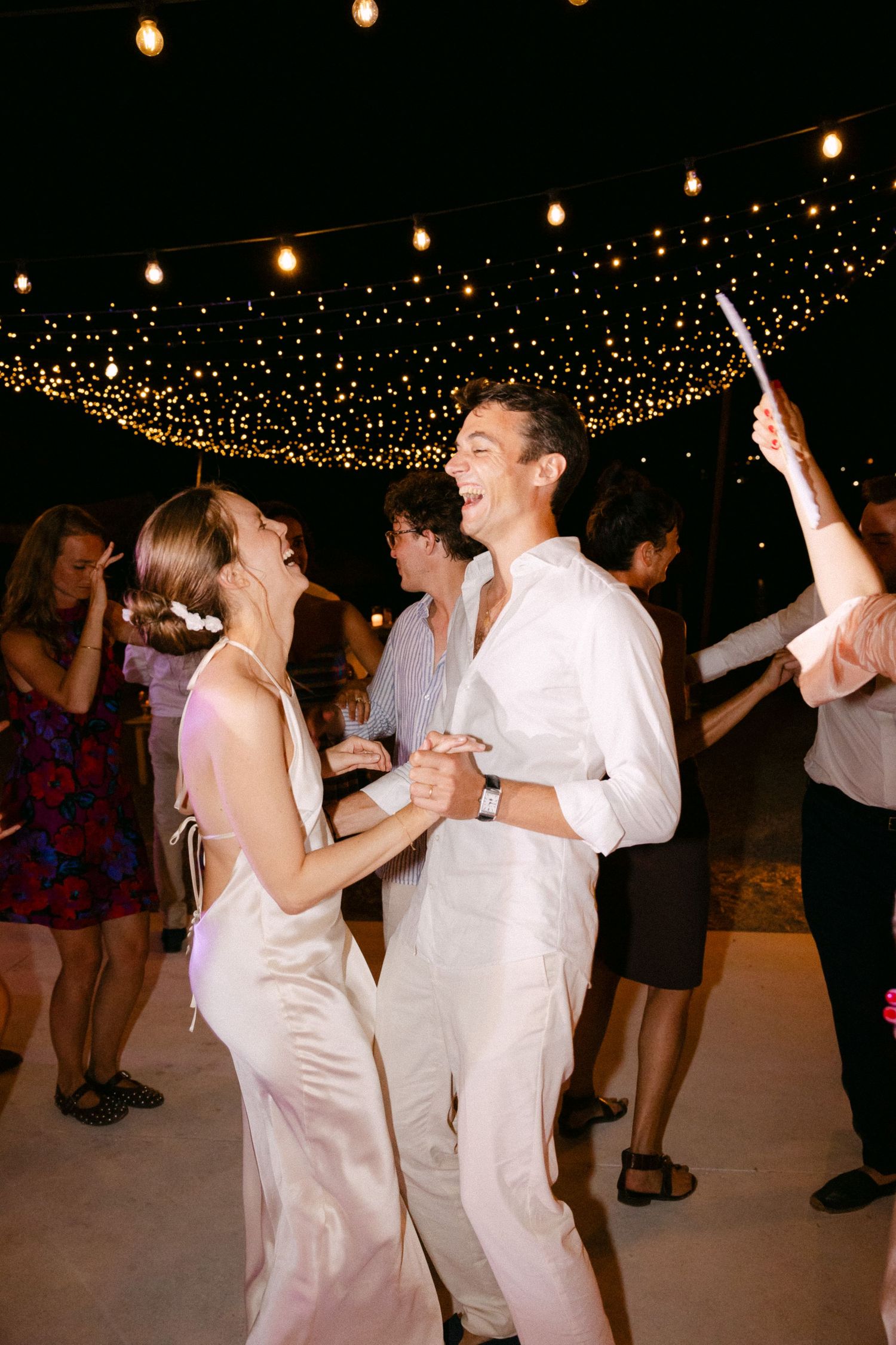a bride and groom dancing with each other during the open-air wedding party of their Spetses wedding