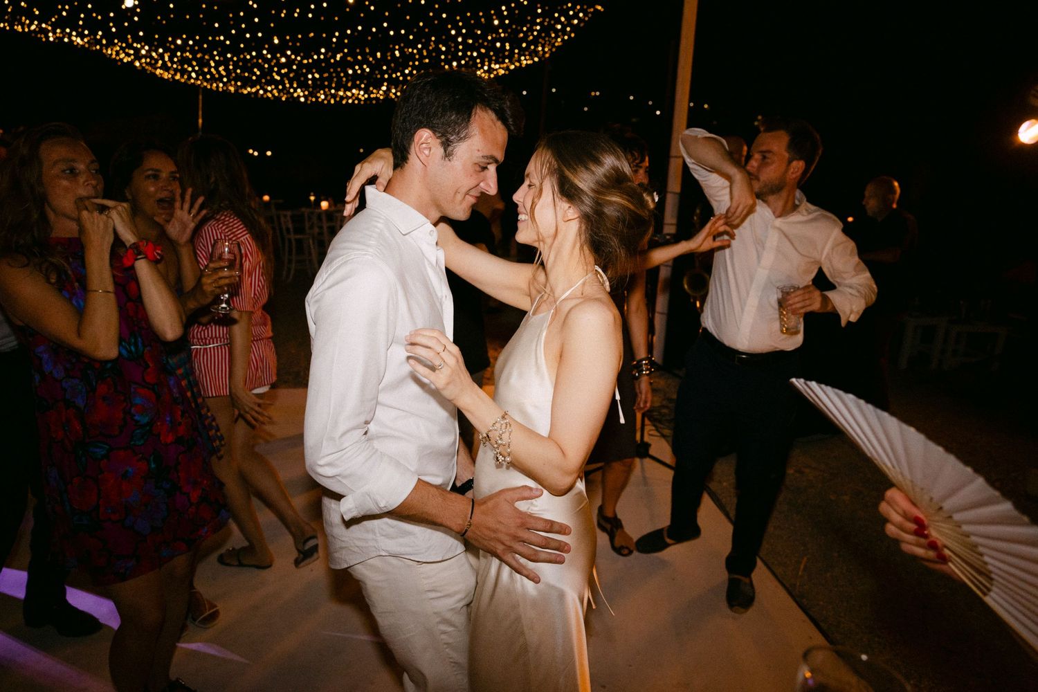 a bride and groom dancing salsa with each other during the open-air wedding party of their Spetses wedding
